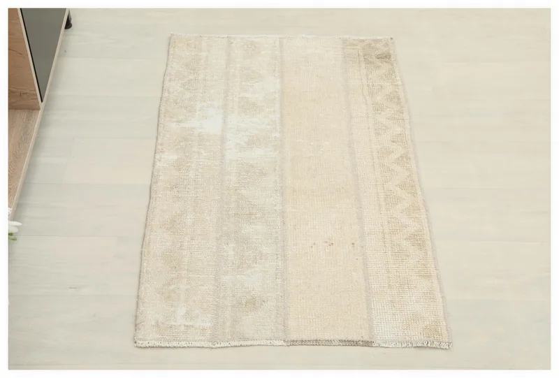 Full top view of the cream distressed geometric rug on a white background.