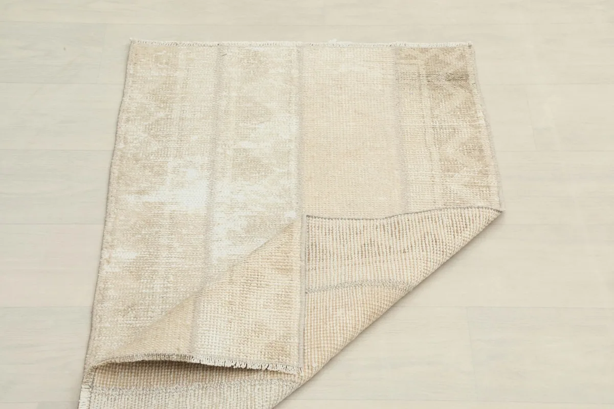 The rug folded to show both the front and back textures, highlighting its flexibility.