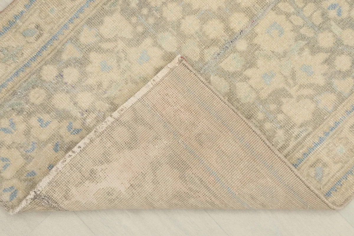 View of the rug's cotton foundation and the reverse side of the hand-knotted construction.