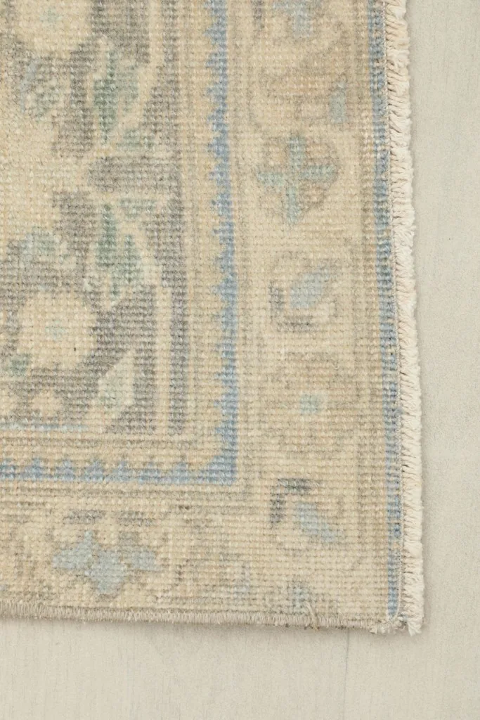 Close-up of the corner and border design, highlighting the blue and beige tones.