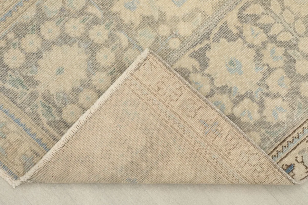 View of the back of the hand-knotted rug, revealing the cotton foundation and construction.