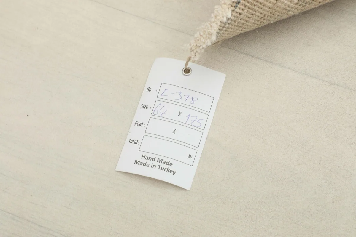 Close-up of the rug's tag, indicating it is hand-made in Turkey.