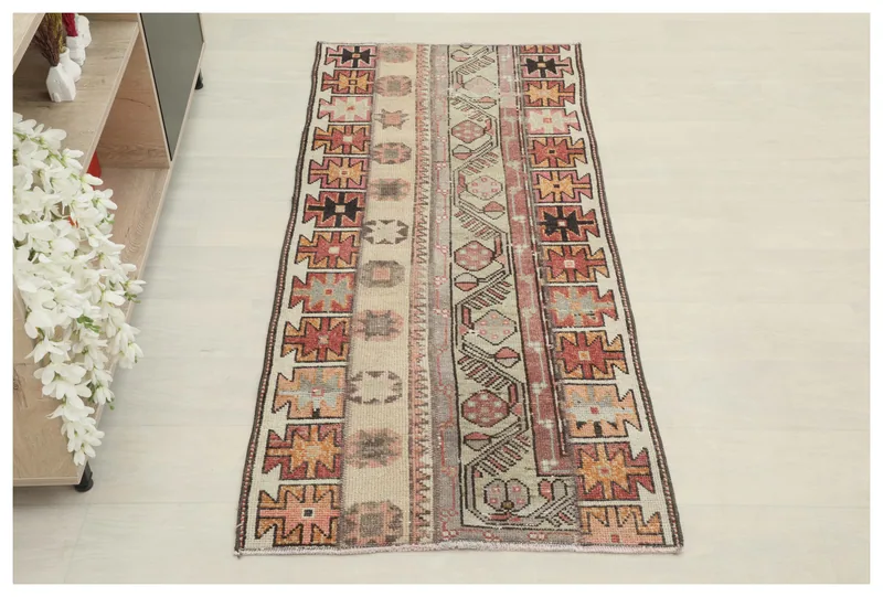 Full top view of the 2'4" x 5'4" beige and rust vintage Anatolian area rug on a white background.