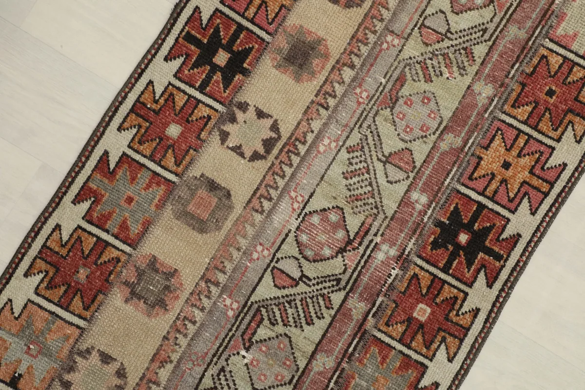 Close-up angled view highlighting the distinct geometric and tribal patterns in beige, rust, and black.