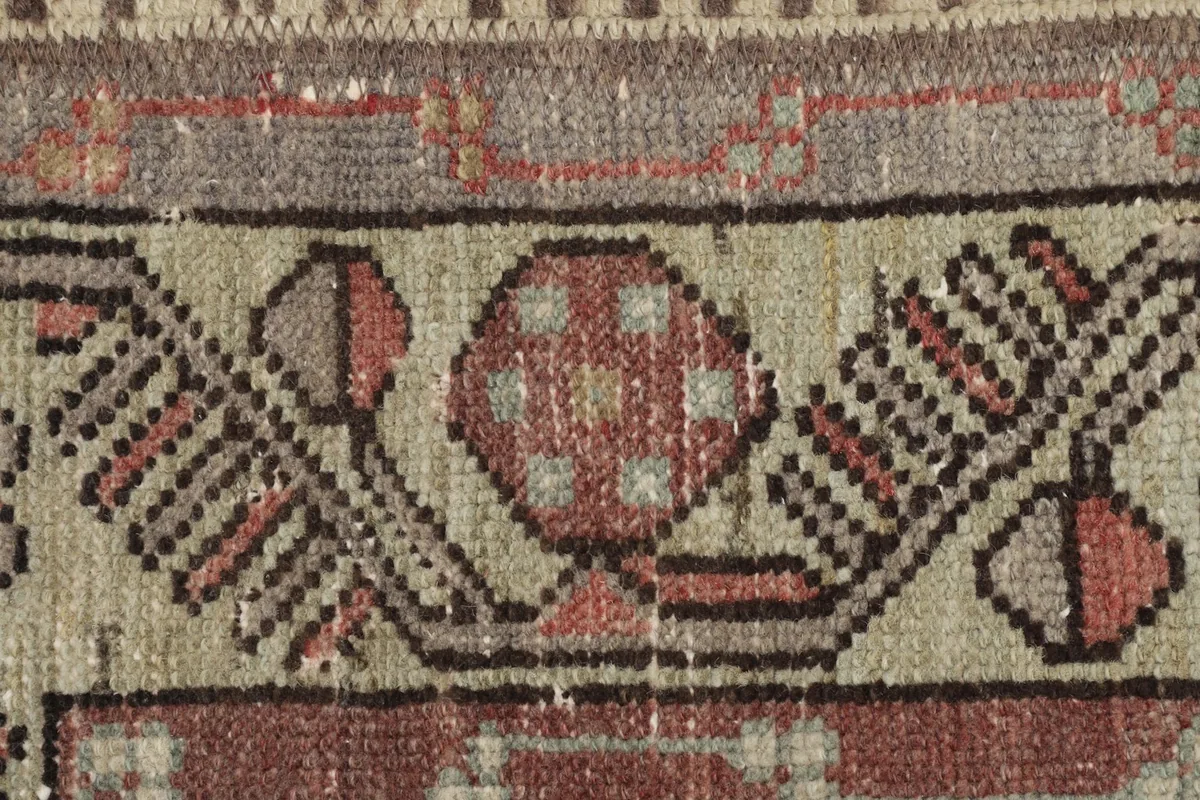 Detailed close-up of the geometric motifs and texture of the low wool pile.