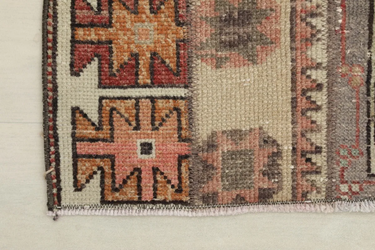Close-up view of one end of the rug, showing the fringe and the overall color palette.