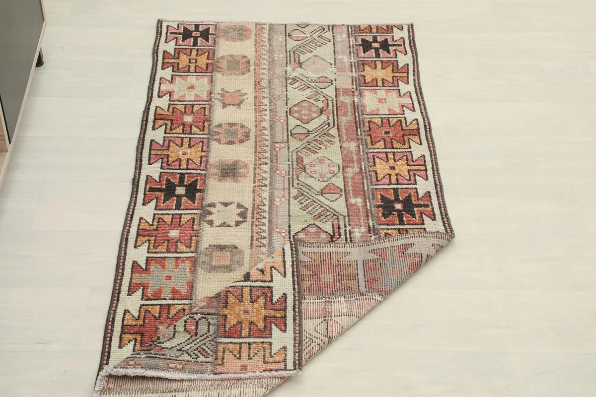 The rug with one corner folded, showing the full design and the backing.