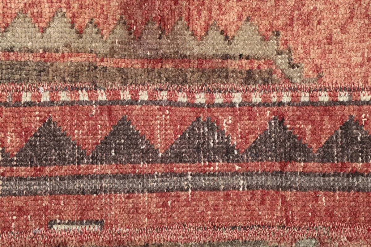 Detailed view of the intricate geometric patterns and color variations within the red and brown stripes