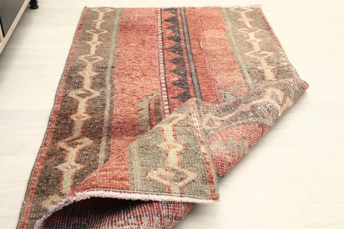 Rug partially folded, illustrating its flexibility and thickness of the wool pile