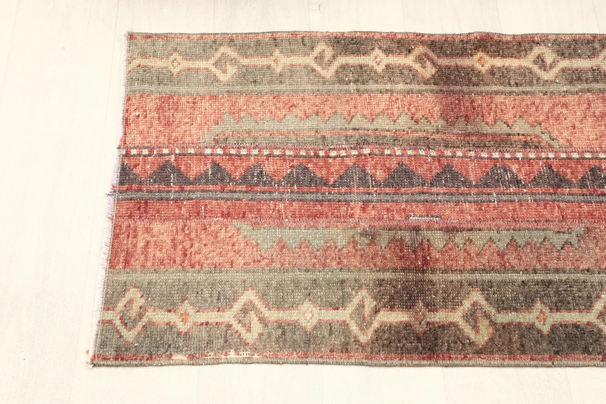 Overhead shot of one end of the rug, showing the border design and fringe detail