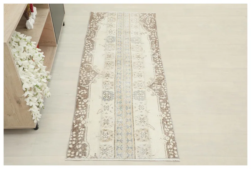 Full overhead view of the 2'3" x 5'9" cream and brown vintage runner rug on a white background.