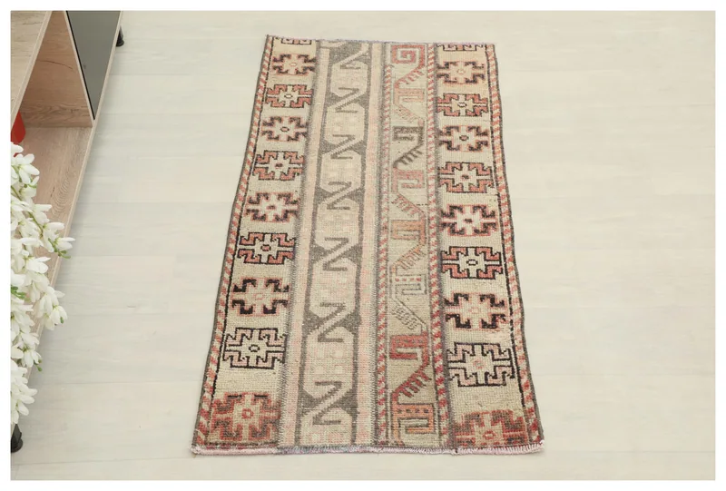 Full overhead view of the beige, rust, and brown tribal geometric vintage Anatolian area rug.