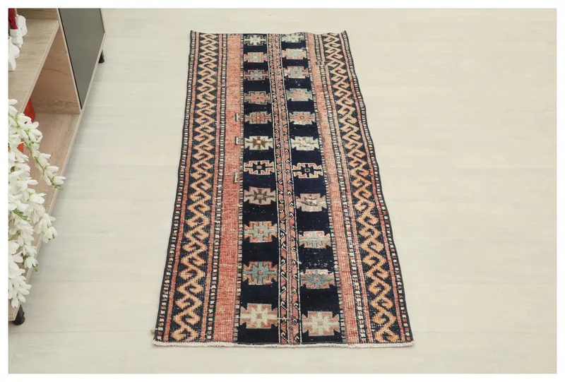 Full top view of the vintage navy and rust Anatolian runner rug on a white background.