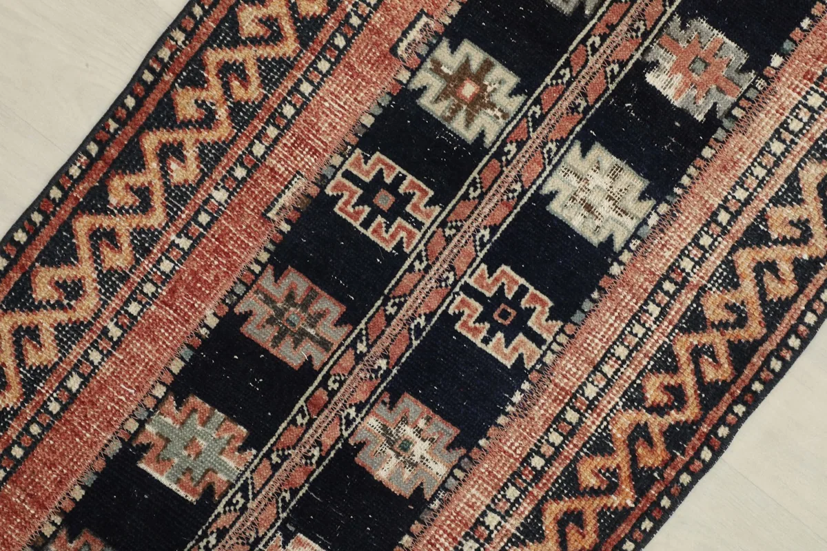 Close-up view of the central navy field with distinct rust and beige tribal motifs.