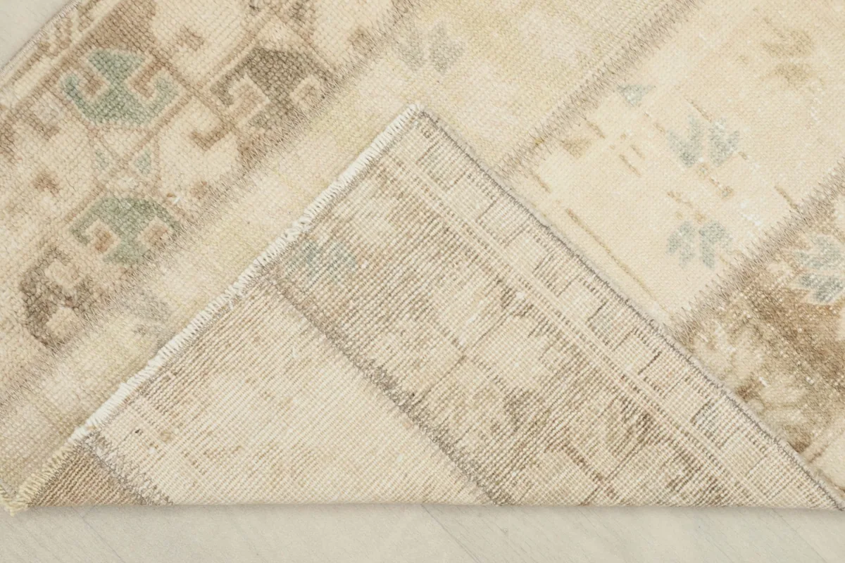 View of the rug's reverse side, revealing the cotton foundation and hand-knotted construction