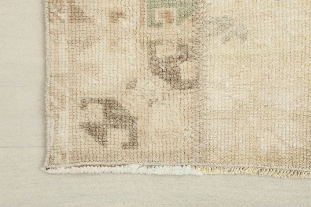 Corner detail showing the low pile and subtle fringe of the vintage hand-knotted rug