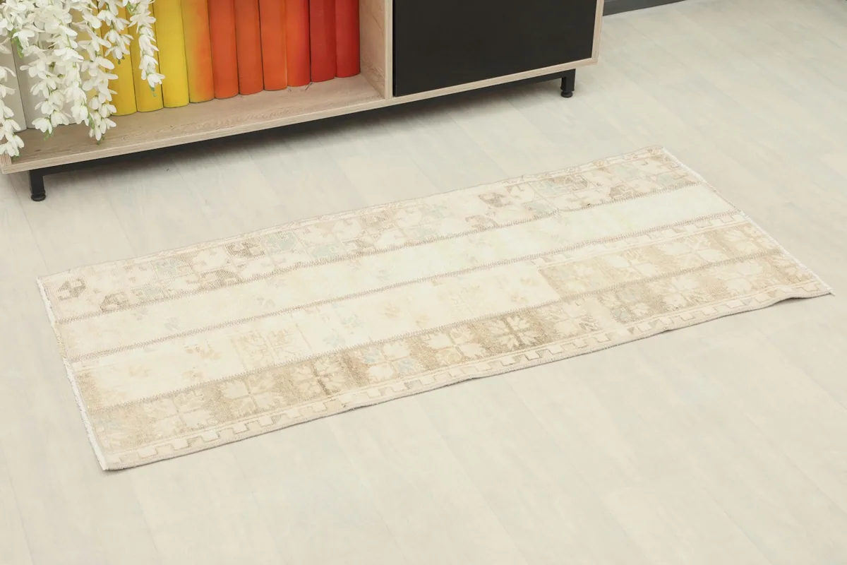 Overhead view of the ivory and beige patchwork rug laid out in a room setting
