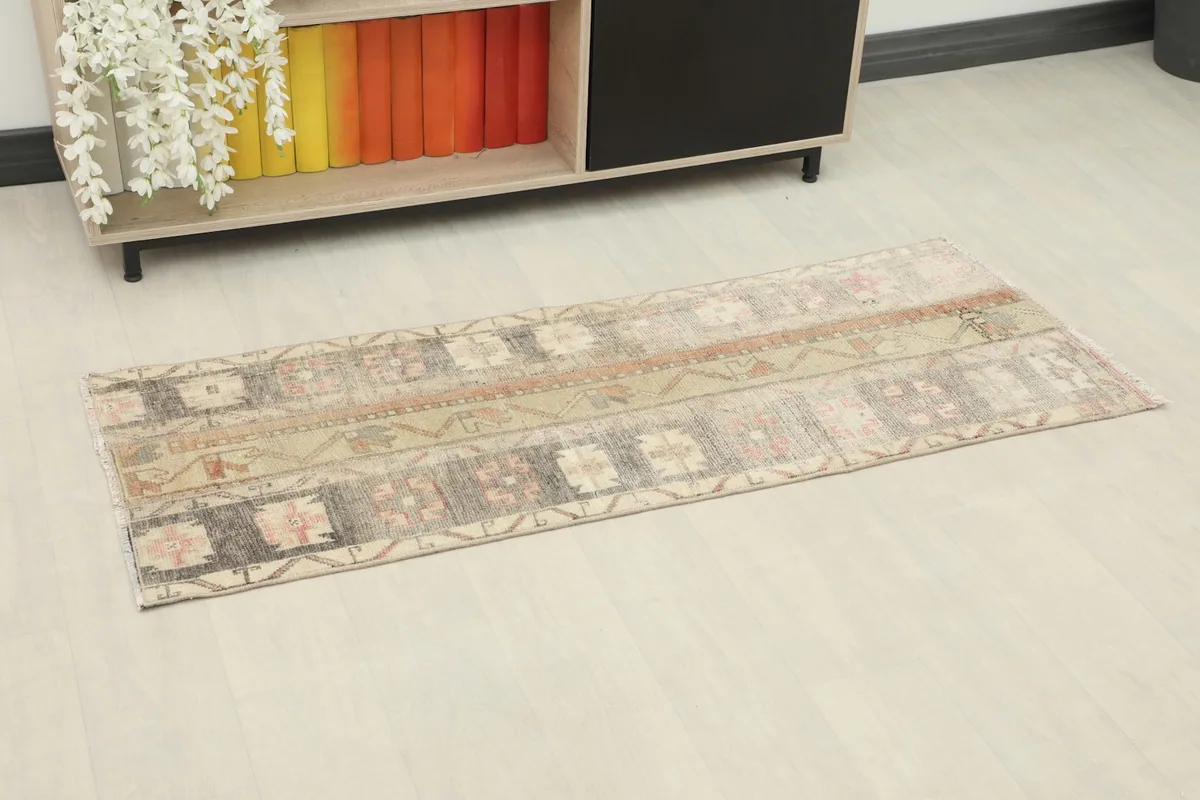 Overhead view of the runner rug placed on a light floor next to a low shelf with books.