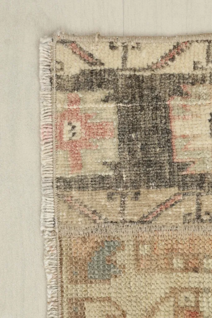 Close-up of the rug's edge, showing the hand-knotted weave and short fringes.