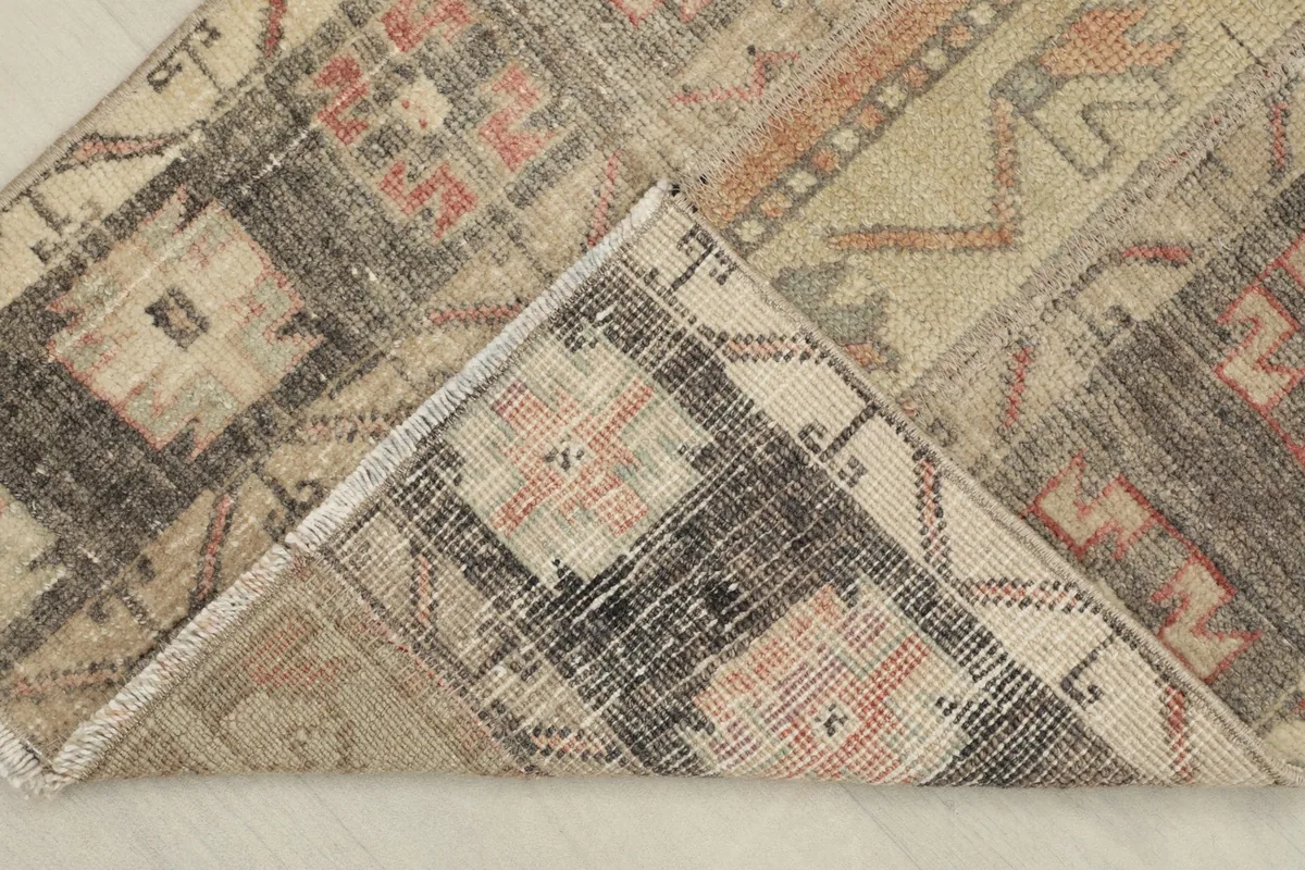 Corner folded back to reveal the cotton foundation and hand-knotted construction of the rug.