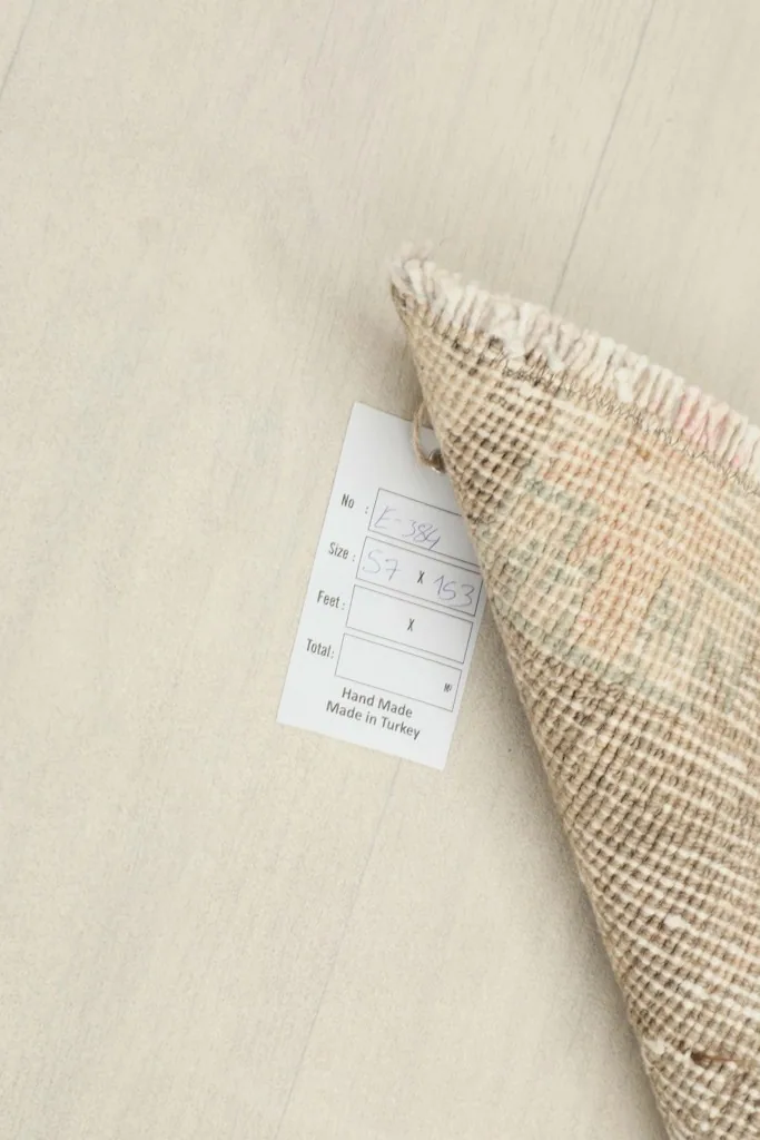 A close-up of the rug's label, indicating its hand-made origin in Turkey and size.