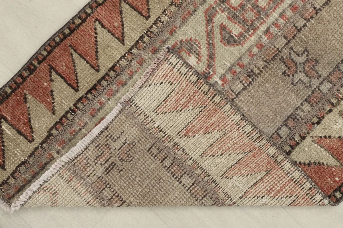 View of the rug's underside and a folded corner, revealing the cotton foundation and knotting.