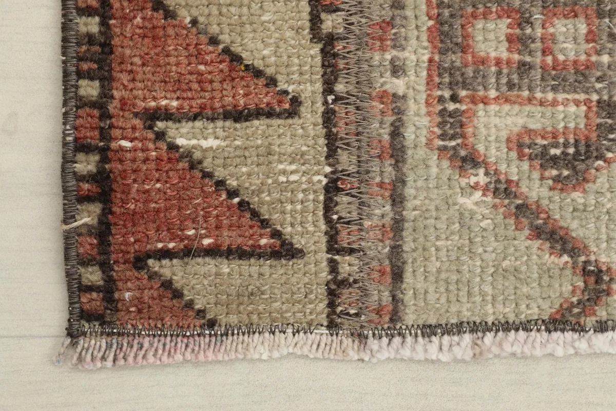 Close-up of the rug's edge, showing the short, natural fringe and the hand-knotted construction.