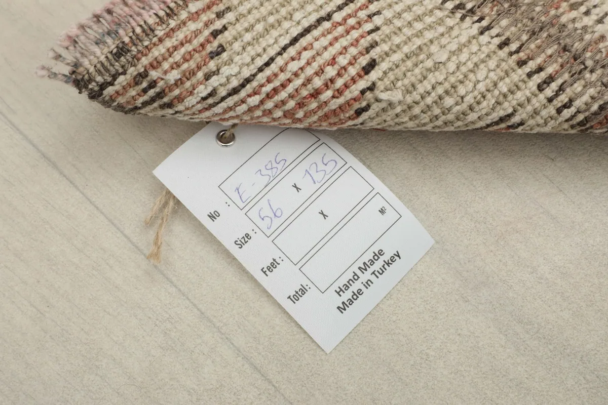 Close-up of the rug's back with a tag showing its dimensions in centimeters.