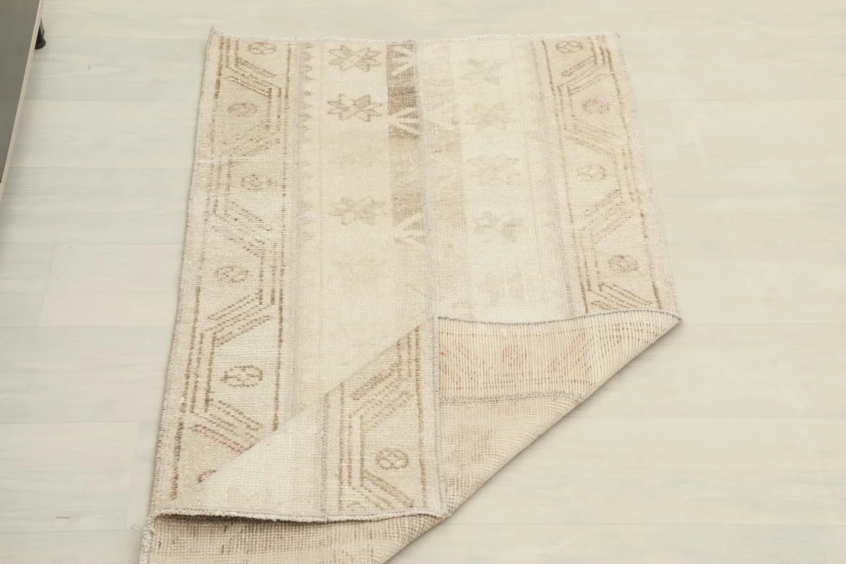 The beige rug folded to show its flexibility and thickness