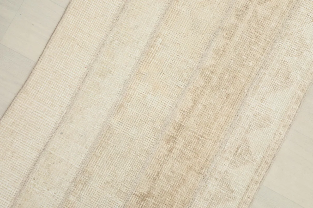 Close-up view showing the textured surface and varying beige tones of the rug