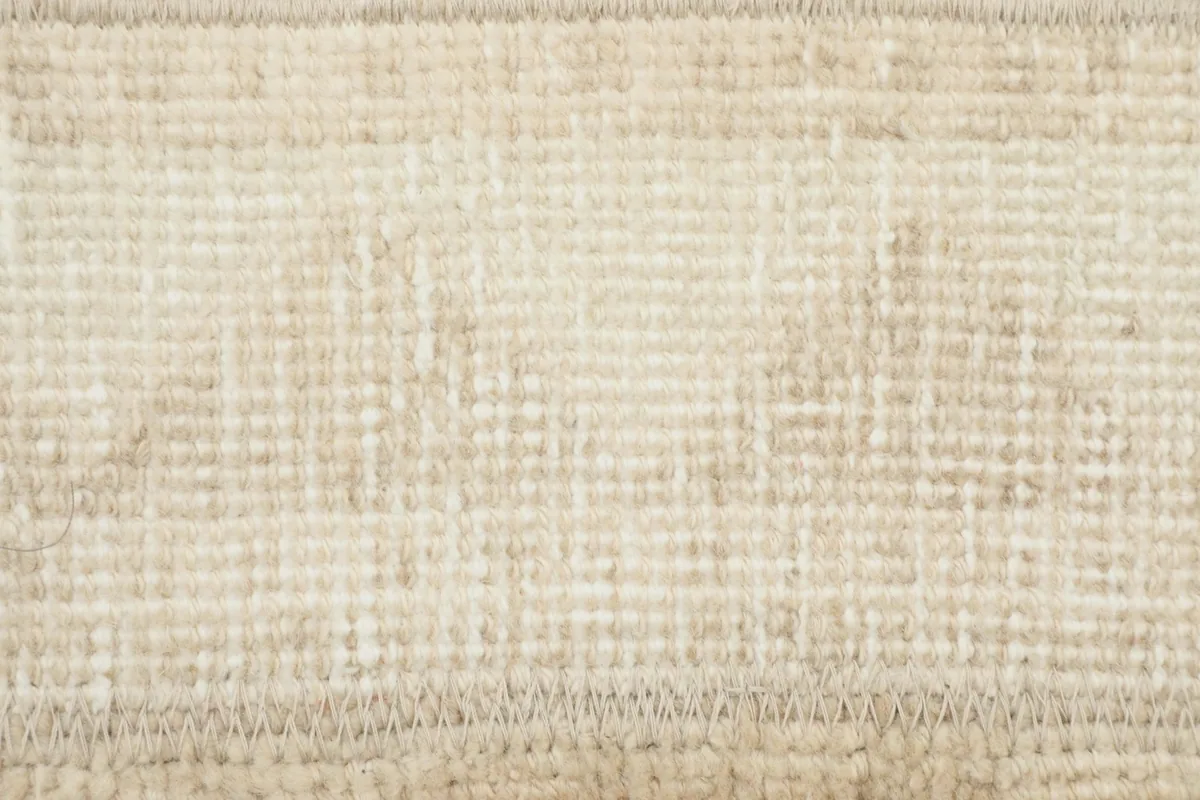 Detailed view of the subtle geometric patterns and low pile texture on the rug