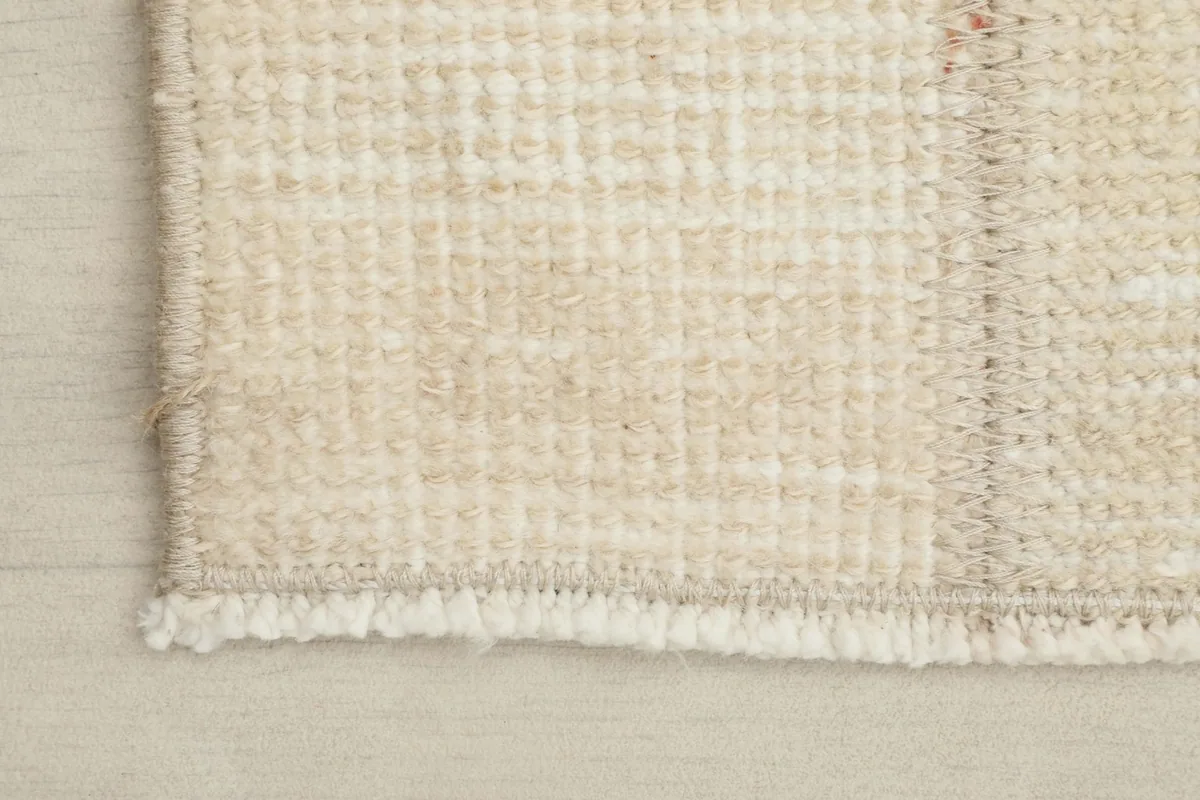 Close-up of the short, textured fringes and edge finishing of the hand-knotted rug