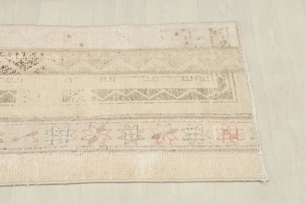 Detailed view of the rug's edge, revealing the varied patterns and subtle color shifts across patches.