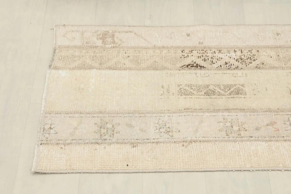 Overhead view highlighting the horizontal arrangement of different beige and cream rug patches.