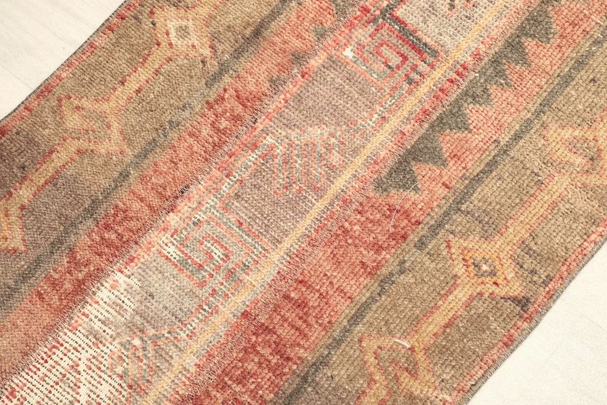 Angled view highlighting the rug's surface texture and the blend of rust, brown, and beige colors.