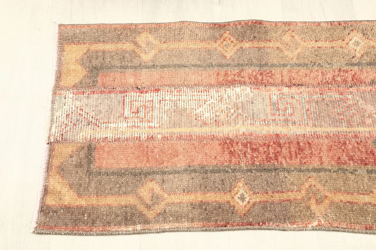 Angled view of the rug's top half, showing the distinct striped panels and their patterns.