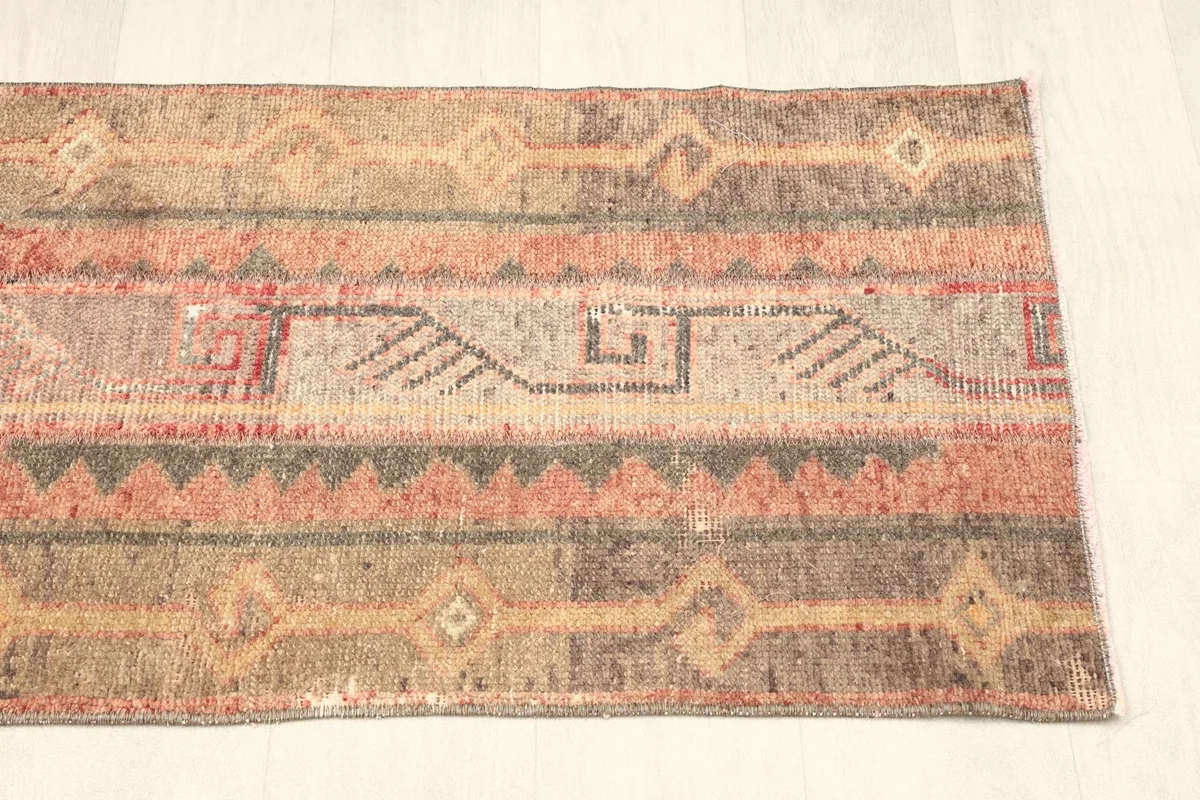 Angled view of the rug's bottom half, focusing on the geometric designs and color transitions.