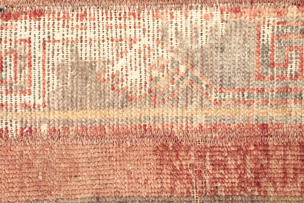 Detailed shot of the rug's central section, revealing intricate geometric motifs and color variations.