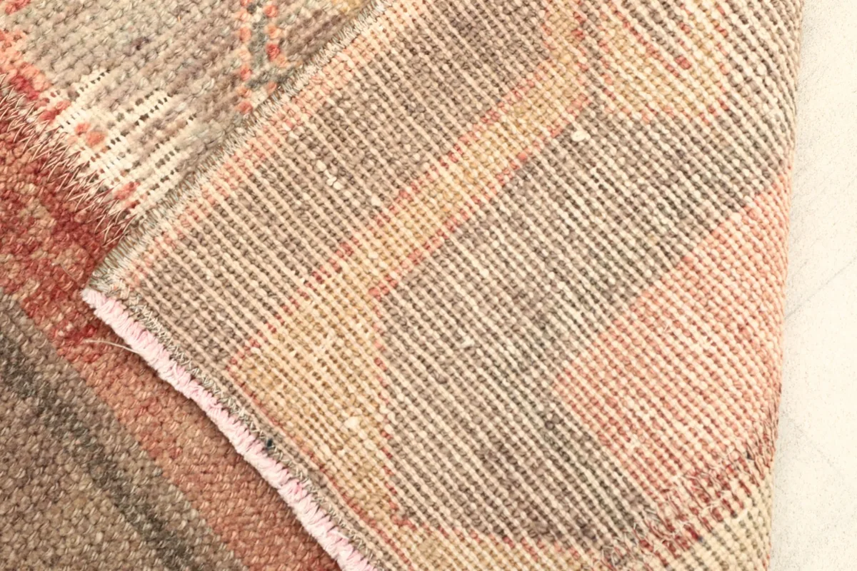 Close-up of the rug's reverse side, revealing the hand-knotted cotton foundation and tight weave.