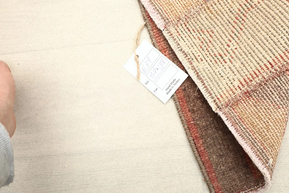 Corner of the rug with a label, demonstrating its authenticity and hand-knotted construction.