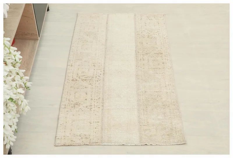 Full overhead view of the beige patchwork vintage Anatolian rug on a white background