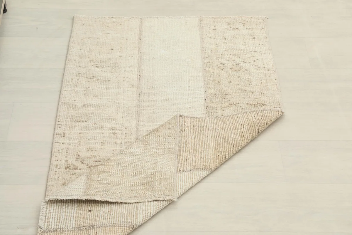 Rug partially folded to show its flexibility and thickness, displaying the back and front