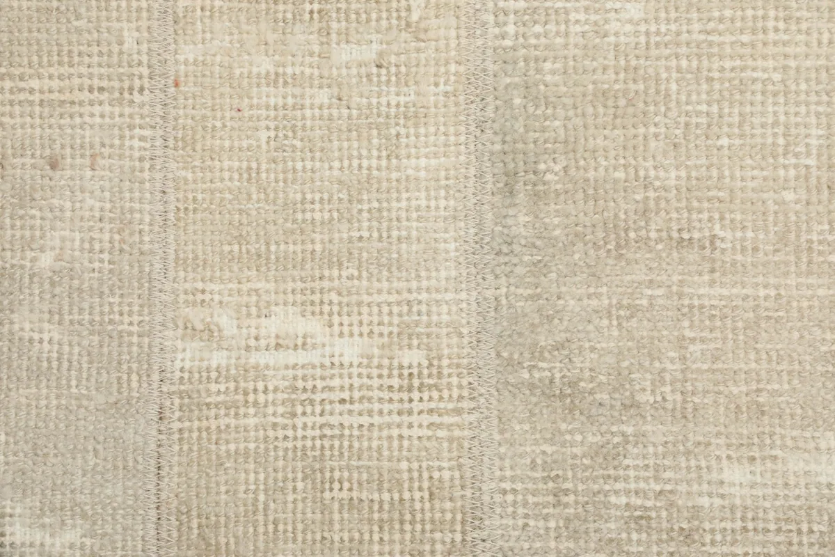 Detailed view of the low wool pile, revealing the intricate knotting and natural wear of the vintage rug.