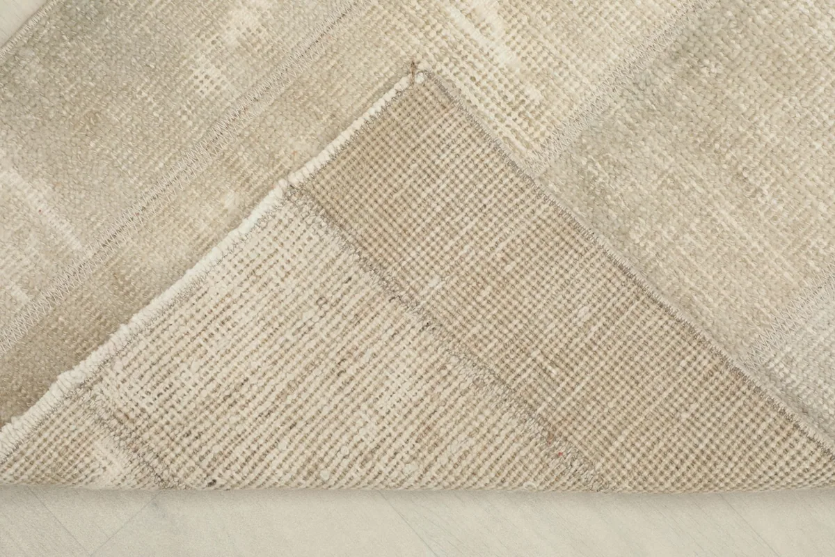 View of the back of the rug, showing the cotton foundation and the reverse of the hand-knotting.