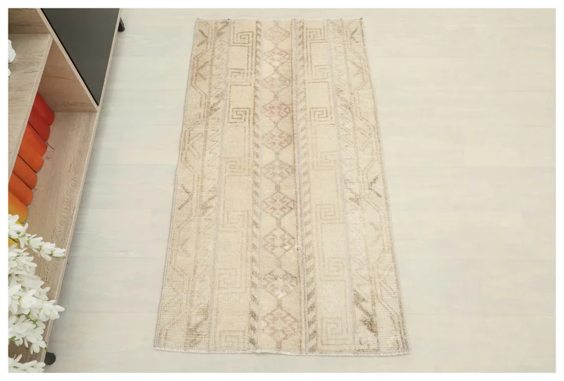 Top view of a beige and brown vintage Anatolian area rug with geometric patterns