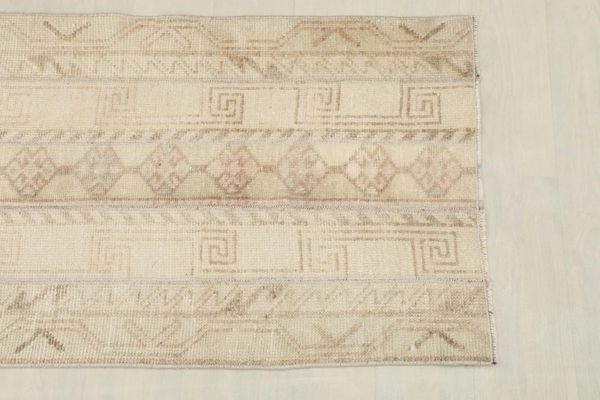 Detailed view of the rug's short end, highlighting the beige and brown patterns