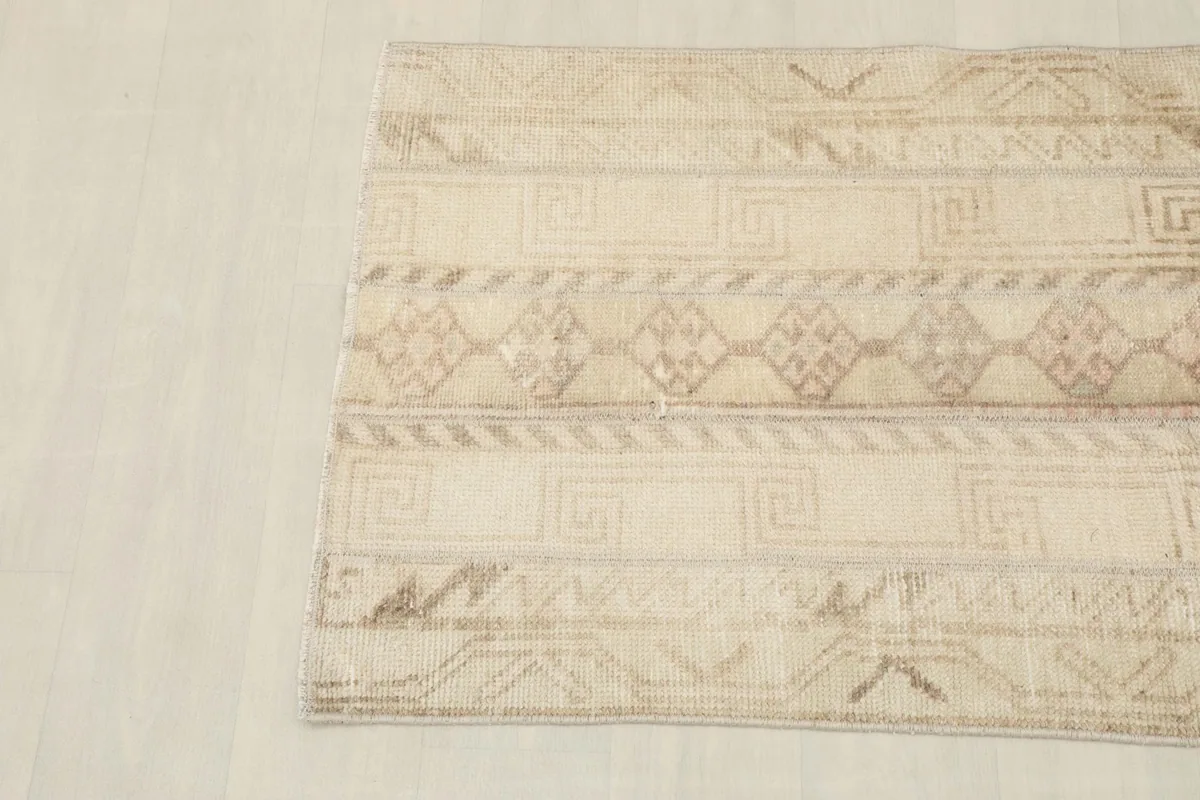 Close-up of the rug's corner, showing the subtle color variations and hand-knotted texture
