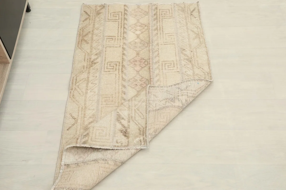 Rug partially folded to show its flexibility and thickness against a light background