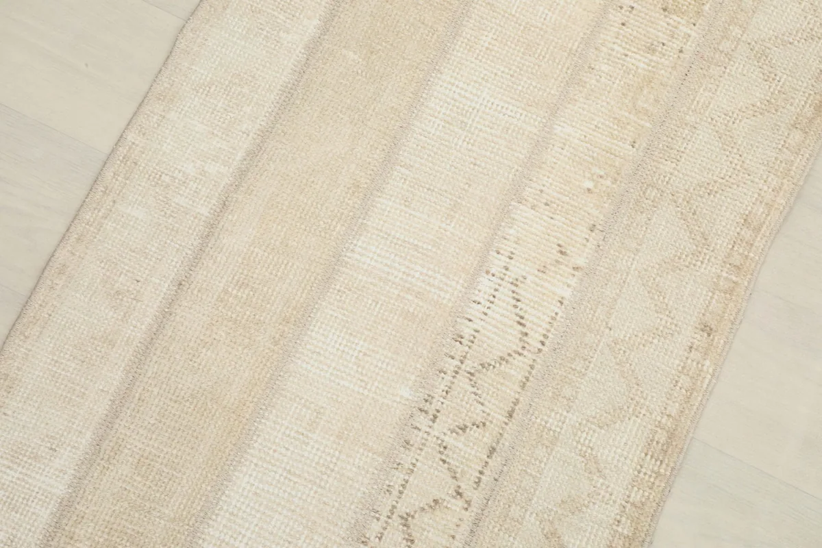 Close-up detail of the rug's surface, highlighting the subtle beige and tan stripes.