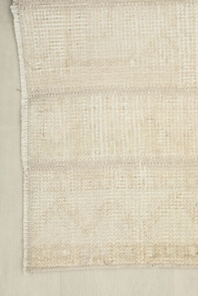 View of the rug's reverse side, showing the cotton foundation and hand-knotted construction.